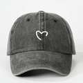 Detalle del bordado de corazón blanco en una gorra de béisbol de mezclilla gris oscuro - Talla única / Negro