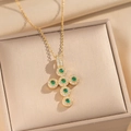 Detail van kruishanger met groene zirkoonstenen en micro-pave kristallen op gouden ketting - Goud Smaragdgroen Zirkoon