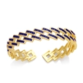 Macro shot of gold-plated bangle featuring square-cut blue cubic zirconia in geometric design - Blue