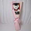 Close-up of white graduation teddy bear in pink bouquet wrap with Best Wishes tag - Light Pink