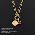 Collana a graffetta dorata con pendente 'L' in strass e ciondolo rubino. - Taglia L / Oro