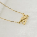Collier doré avec pendentif chiffre 2024 en acier inoxydable sur fond blanc doux - 2014