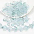 Detailed view of light blue moon and star shaped iridescent glass beads for DIY jewelry - Ink Jade Gradient