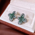 Macro di orecchini vintage a fiore con zirconi verdi e bianchi su metallo scuro lucido - Tono Argento Verde (Perno Argento 925)