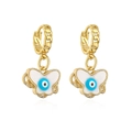 Macro detail of gold plated butterfly earrings with blue evil eye and white enamel - Gold Butterfly Evil Eye