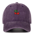 Close-up of red cherry embroidery on a purple washed denim baseball cap with retro texture - Purple