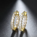Macro detail of luxury gold hoop earrings with square-cut cubic zirconia in prong setting - Gold