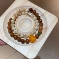 Detalle de pulseras de doble capa con cuentas de piedra natural sobre una bandeja de madera - Cuentas de Concha de Kook (Con Caja de Regalo)