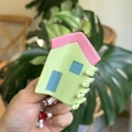 Detail of green house hair claw clip with pink roof held against nature background - Approx 8.5cm / Green House