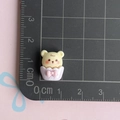 Dettaglio mini orsetto in resina su tappetino millimetrato per mostrare la misura 1,5cm - Cupcake Testa di Orso Viola
