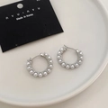Dettaglio di orecchini a cerchio in argento con perle su un vassoio di ceramica - Argento / Perno per Orecchini
