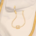 Detailansicht eines 18K vergoldeten Armbands mit klaren Zirkonsteinen auf einer Keramikschale - Gold Rechteckiger Dekorativer Stil (4#)