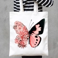 White canvas tote bag featuring a pink and black succulent butterfly print on a model - Succulent Butterfly (STD707-J)