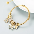 Detail of gold cable bracelet with crystal charms and a sparkling diamond butterfly pendant - White