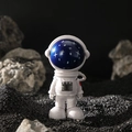Statuina di astronauta in resina bianca con casco stellato su superficie lunare - Testa Grande Cielo Stellato