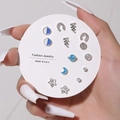Detailed set of silver stud earrings with stars and moons held by a hand - 9 Pairs Set / E0487-1 (Silver Blue Rhinestone Set)