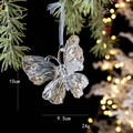Ornement papillon pailleté doré accroché à une branche de sapin de Noël festive - Papillon