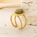 Detalle de anillo vintage dorado con piedra natural verde sobre base de piedra beige - US 6 / Dorado