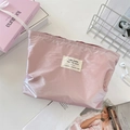 Vista dall'alto della borsa da trucco rosa metallizzato con accessori su tavolo bianco - Rosa Carne