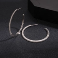 Detail of silver hoop earrings with pave-set white cubic zirconia on a dark display - Hoop Earrings-Silver-4cm
