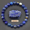 Macro shot of natural lapis lazuli beaded bracelet with raw blue gemstone on grey base - Natural Lapis Lazuli