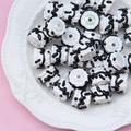Macro shot of white cylindrical resin beads with black wave patterns for DIY crafts - White Bead Black White Cream