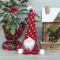 Lutin de Noël rouge en peluche avec bonnet à motifs cœurs sur fond de bois festif - Rouge