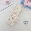 Floral fabric makeup brush roll organizer with pink ribbon tie on a white surface - Twill Floral Beige
