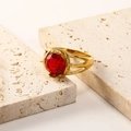 Macro shot of 18K gold titanium ring with round red zircon on textured stones - US 6 / Gold Red Zirconia