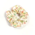Detail of a satin Easter scrunchie featuring pink rabbits and floral garden prints - Cream Floral
