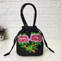 Close-up of colorful floral embroidery and drawstring closure on black ethnic bucket bag - Two Peace Flowers