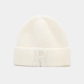 Détail du bonnet en maille côtelée crème avec un grand patch brodé lettre R sur le revers - Blanc