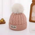 Detail der Strickstruktur einer rosa Strickmütze mit großem weißem Kunstfellbommel - Ca. 2-5 Jahre alt / Rosa