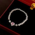 Detalle de la pulsera de perlas con circón de corazón rosa en una caja de regalo roja - Pulsera de Perlas de Corazón Rosa