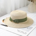 Detail of flat top straw boater hat with dark green ribbon and golden metal logo - One Size / Off-White Satin Bow Boater Hat