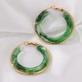 Detailed view of green marble resin C-hoop earrings with gold-tone borders on silk - Green