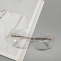 Dettaglio degli occhiali cat-eye trasparenti con eleganti stanghette in metallo dorato - Bianco Trasparente