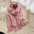Soft pink faux cashmere scarf with fringe details laid on a plush cozy background - Baby Pink