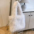 Detailed view of a white fluffy faux fur tote bag with fringe hanging on a metal hanger - Off White