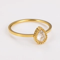 Primo piano di anello dorato con zircone a goccia e delicata decorazione in milgrain - US 6 / Zirconia a goccia d'oro