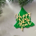 Nahaufnahme von grünem Acryl-Weihnachtsbaum-Topper mit goldenem Happy New Year Schriftzug - Goldener Buchstabe grüner Weihnachtsbaum / Ca. 7 cm Höhe