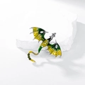 Detail of dragon brooch with green enamel wings and sparkling zircon scales on white stone - Yellow Green Gradient Silver Base
