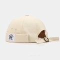 Close-up of beige canvas Miki hat featuring Brooklyn embroidered tag and metal buckle - Beige