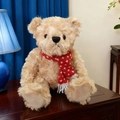 Plüschiger hellbrauner Teddybär mit rot-weißem Strickschal sitzend auf einem dunklen Tisch - 25cm / Rotes Modell mit Kleinen Schneeflocken