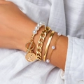 Dettaglio del set di quattro bracciali dorati con perle e ciondolo regina sul polso - Multilayer Queen Coin Pearl Style (3894) / Oro