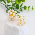 Star-shaped pearl stud earrings in gold setting displayed on a white textured stone - White Multi-Pearl Flower Cluster Studs