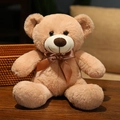 Soft light brown plush teddy bear with a dark brown satin bow in a cozy home setting - 35cm / Camel