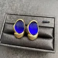 Vintage style oval stud earrings with blue textured glass in a matte gold-plated frame - Blue