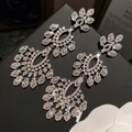 Close-up of sparkling zircon flower drop earrings on black display with white flower - 67# Silver Zirconia Flower Hollow Tassel Drop Earrings