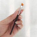 Angled eyebrow brush with black handle and orange-brown bristles for eye makeup detail - Budget Angled Brow Brush